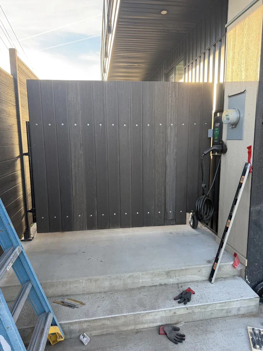 The finished custom privacy gate clad in dark vertical boards